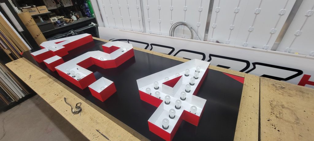 Bulb-lit 424 numerals on the shop bench before installation