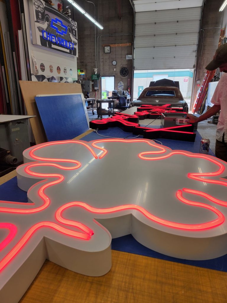 Pink LED neon-flex flower sign lit up and under test in the Summit Signs shop