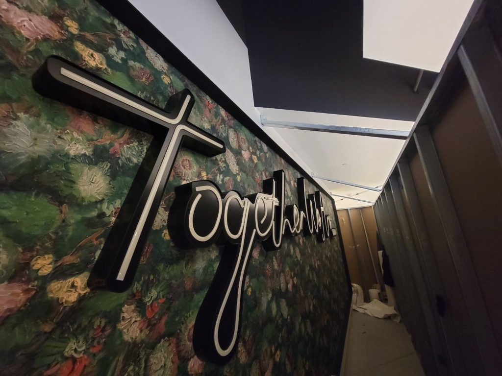 Script lettering installed on a floral feature wall before the LED neon-flex is switched on