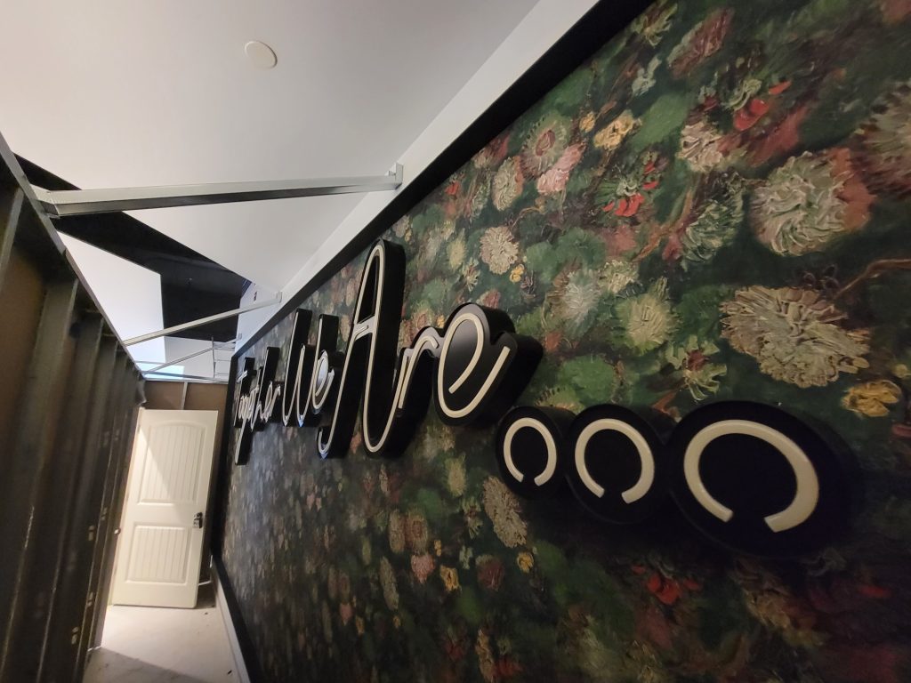 Dimensional lettering installed on a floral feature wall, lights off